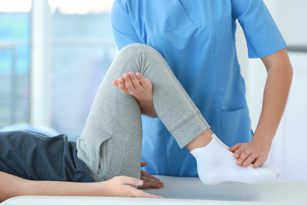 Chiropractor treating patient for knee pain
